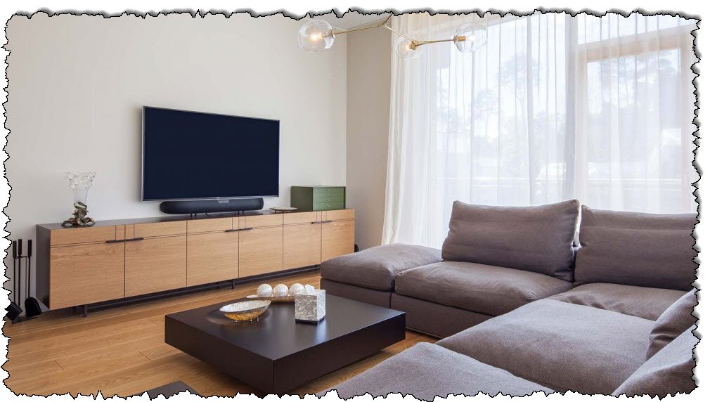 تحتوي غرفة المعيشة العصرية على مجموعة أرائك وتلفزيون بشاشة مسطحة.