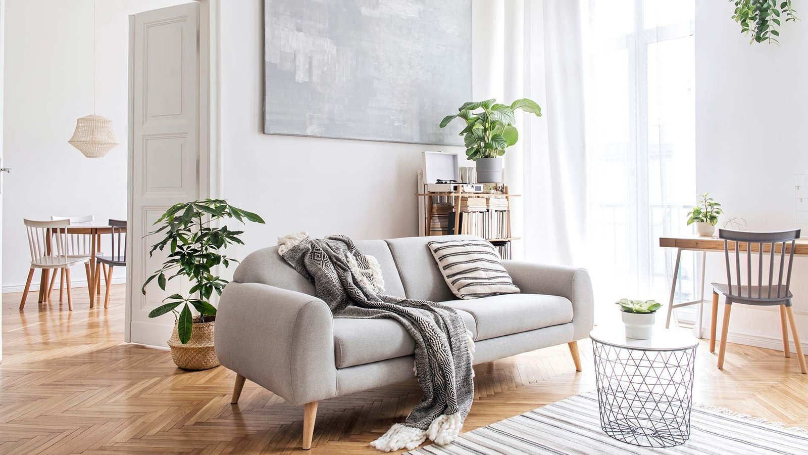 A brightly lit living room decorated with modern furniture and plants.