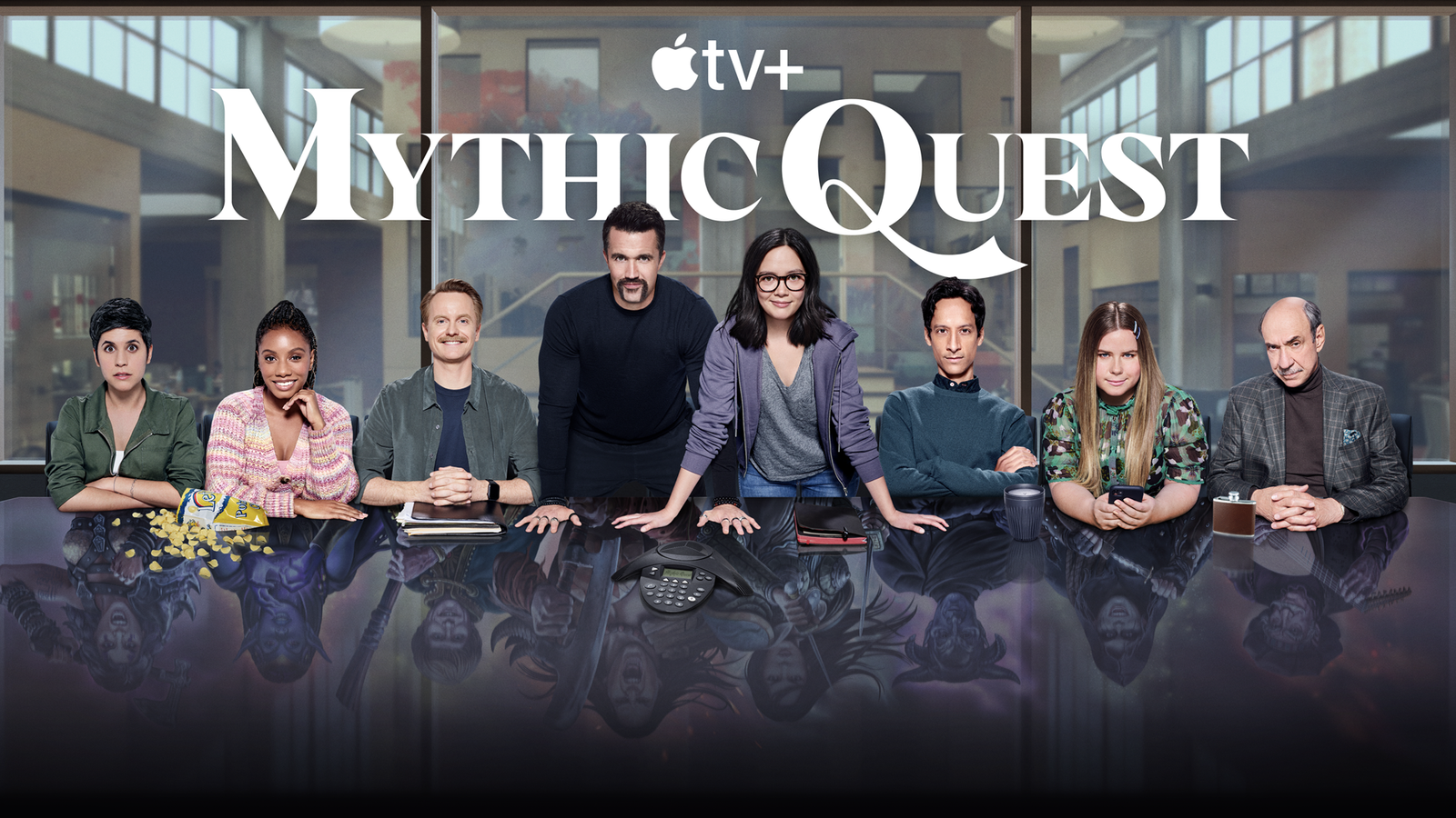 The cast of Mythic Quest behind a conference table.